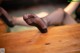 A woman in black stockings is sitting on a wooden table.