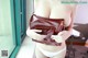 A woman in a white panties holding a brown purse.