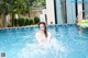 A woman in a swimming pool with an inflatable raft.