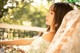 A woman sitting on a balcony with flowers in her hand.