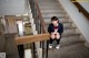 A woman in a school uniform sitting on a set of stairs.