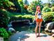 A woman in a sailor outfit standing in front of a pond.