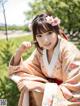 A woman in a pink kimono with a flower in her hair.