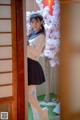 A woman in a sailor outfit standing in front of a door.