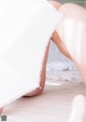 A woman laying on a bed under a white sheet.